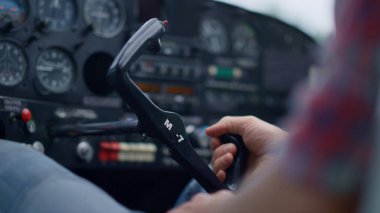 Aviator turning steering wheel small private airplane cockpit on aerodrome close up. Unknown aviation engineer sitting plane cabin driving lightweight aircraft to parking. Air transport concept.