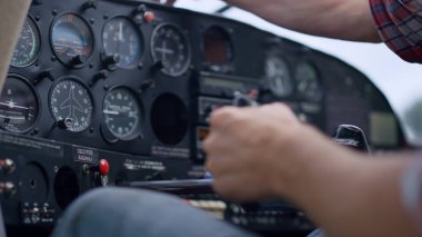 Hand airman driving airplane checking indicators modern control panel before flying close up. Unknown man aviator preparing aircraft to flight starting plane using key. Aviation skills concept.
