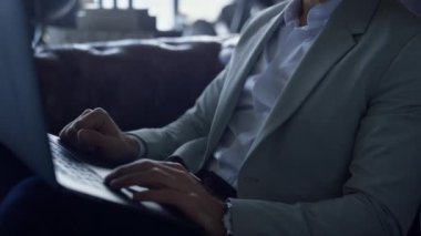 Businessman hands working computer dark interior office close up. Unrecognizable man boss writing business email. Successful unknown executive browsing internet at leather sofa luxury workplace