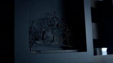 Bicycle metal sculpture loft apartments closeup. Creative design object at cube shelf dark interior. Elegance style figure in luxury conference room. Decorated item souvenir statuette concept 