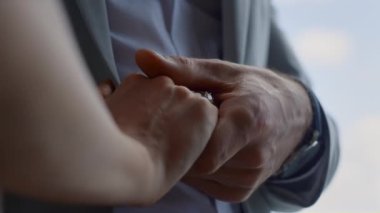 Lovely couple hands connecting in cloudy sky background. Unrecognizable man and woman arms holding at luxury hotel. Closeup unknown people touching gently at lounge terrace. Unity and love concept 