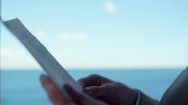 Businessman hands reading papers at ocean view hotel closeup. Entrepreneur arms holding documents at panoramic window office. Unknown director checking analyzing financial statistics at workplace 
