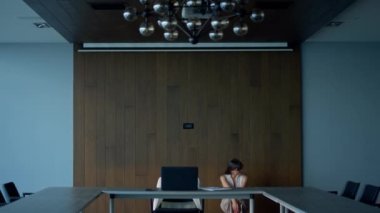 Sad freelancer looking solution in office. Thoughtful woman walking meeting room considering problem difficult task. Stressed businesswoman searching idea alone. Nervous manager think project strategy