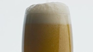Şeffaf bardakları dolduran el yapımı içecek. Lager akışı, alkollü içeceklerde köpük yaratıyor. Çok yavaş çekimde. Ipa bira jeti makro oluşturan cam kabarcıklar oluşturur