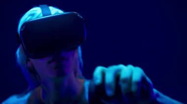 Serious man VR glasses using controllers in videogame world closeup. Metaverse male person exploring analyzing virtual global internet connection space. Big data and future digital technology concept