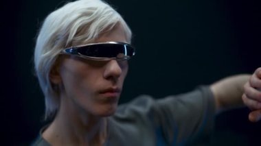 Thoughtful user examining checking VR technologies closeup. Blonde man headset exploring metaverse, touching considering virtual reality subjects slow motion. Digital modern high-tech world concept 