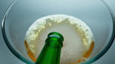 Şeffaf cam çekimde şişe doldurma birası. Lager akışı alkollü içecek teknesinde köpük yapıyor. Çok yavaş. Ipa içecek jeti cam kabarcıklar oluşturarak makro oluşturur