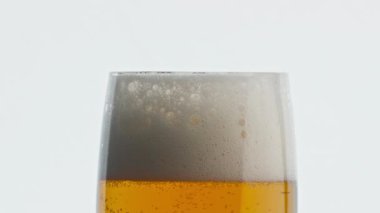 Statik köpüklü bira kadehi beyaz arka plan. Köpürmüş alkol içeceği dokusunu yakından çek. Şeffaf camların içinde zıplayan karbondioksit sıvısı. Makro alkollü bira. Temiz cam ipa. Bira fabrikası konsepti