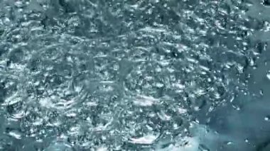 Küçük hava kabarcıkları pürüzsüz su yüzeyine yakın çekim için yükseliyor. Şeffaf mineral içeceği doldurucu bardaklar süper yavaş çekimde. Beyaz arka planda filtrelenmiş su jeti dalgalanması. İçecek konsepti 