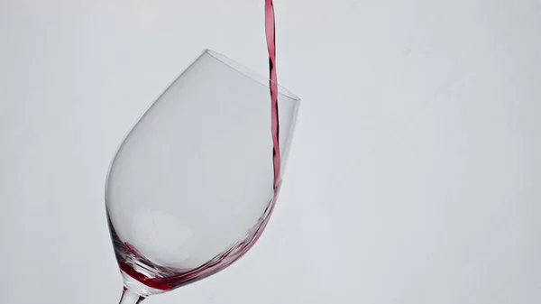 红酒倒酒杯特写慢动作 酒精美味的液体灌满干净的高脚杯 新鲜的玫瑰饮料在酒瓶的白色背景中飘扬 奢华优雅的小贴士概念 — 图库照片