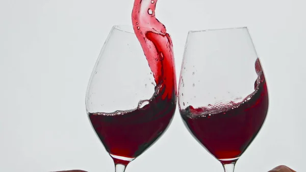 赤い飲料船の閉鎖を上げるクリンク エッジのトーストグラスの白の背景にワインが飛び散るローズ 季節の高価な酔わせる液体お祝い応援ジェスチャークリアゴブレット — ストック写真