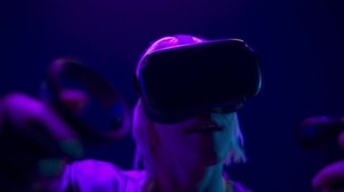 VR headset man playing videogame closeup. Emotional gamer immersed in 3D examining virtual reality world black background. Addicted guy admiring augmented space. Metaverse technology concept 