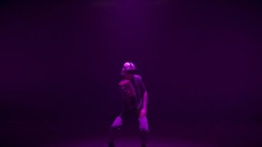 Sanal gerçeklik hipster 'ı neon ışıklarda dans ediyor. Metaverse oynatıcı kulaklıkta simülasyon yaşıyor. Oyundan zevk alan tanınmamış enerjik oyuncu. Futuristik artırılmış oyun performansı.