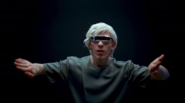 Fütürist gözlüklerle artırılmış gerçeklik oynayan etkileyici bir adam. Siber adam yüksek teknoloji aygıtına metaevren simülasyonunu daldırdı. Çevrimiçi dünyaya adım atan heyecanlı sarışın oyuncu. Gelecekteki eğlence teknolojisi.