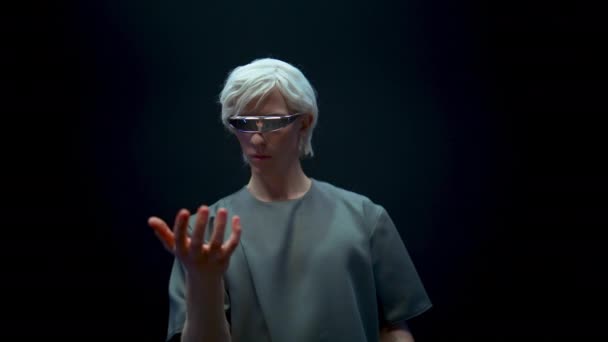 虚拟真人眼镜经历模拟特写 未来派金发碧眼的家伙在变形金刚中给虚拟物体做手势 在高科技耳机里玩增强型游戏的时髦青少年休息 — 图库视频影像