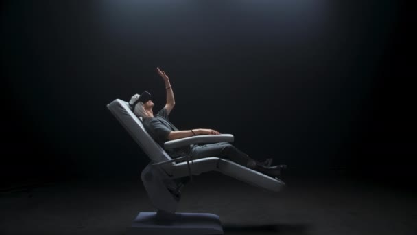 閉鎖制御センサー男浸漬Vr世界 ホログラフィックメガネの人は 仮想現実の経験を得る サイバーパンクシルバーヘアゲーマーは インタラクティブなアームチェアに座って拡張されたスペースを探索 — ストック動画