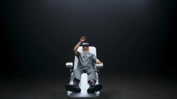 ナノテクノロジーの男がVr暗い部屋に没頭 将来のデバイス人はコンソールシミュレーションの遅い動きを経験します インタラクティブな椅子で触覚手袋を楽しむプロの男 仮想現実 サイバー空間 — ストック動画