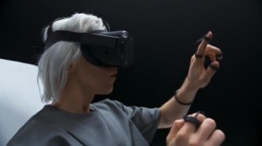 Sanal dünya oyunu oynarken birbirine dokunan adam. Artırılmış gerçeklik kulaklığı takan odaklanmış oyuncu stüdyo ışığında eğleniyor. Man VR dijital alanı. Metaverse 3d modern teknoloji kavramı