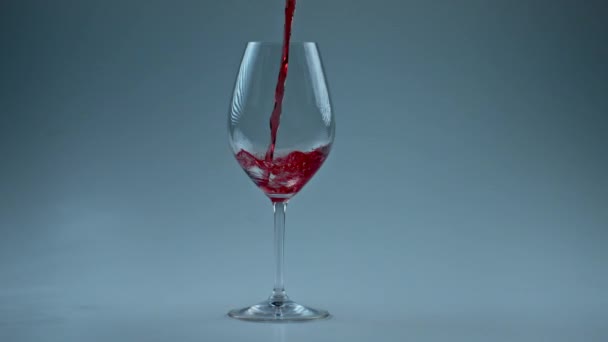 有毒饮料灌满高脚杯慢动作 把酒精液体倒入洁白的酒瓶底 红酒在玻璃杯中形成美丽的波浪 玫瑰射流透明容器壁 — 图库视频影像