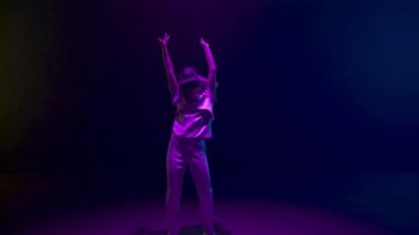 Neon oyuncular karanlık siber uzayda kulaklık takıyorlar. Gelecekçi kadın metaevren teknoloji simülasyonunda VR konserinden zevk alıyor. Bilinmeyen enerjik kız sanal gerçeklikte rahatlıyor. Siber gelecek kavramı.