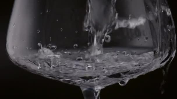 Czysta Woda Przezroczystym Kielichu Czarnym Tle Zbliżenie Kryształowy Napój Wlewający — Wideo stockowe