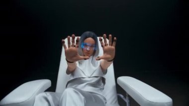 Haptic sensörleri, kadını koltuktan uzaklaştırıyor. Sanal gerçeklik kulaklığı takan kişi gelecekteki siber uzayı keşfediyor. Akıllı genç arttırılmış gerçeklik yazılımı karanlık odayı kullanıyor. Metaverse konsepti 
