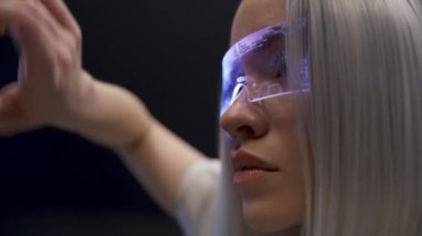 3D gözlüklü kadın metaverse gece görüntülerini aşırıyor. Akıllı odaklı sarışın oyuncu fütüristik görünmez arayüz veri siyah fon oynamaktan zevk alıyor. Geliştirilmiş gerçeklik, gelecekteki teknoloji kavramı