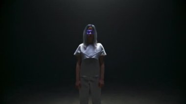 Portatif siber kız artırılmış gerçeklik gözlükleri. Karanlık arka planda dijital 3D gözlük takan güzel fütürist kadın. Odaklanmış oyun simülasyonu ışığa daldırıyor. Sarışın siber punk modeli konsepti.