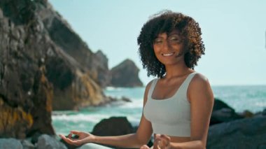 Lotus pozisyonunda poz veren güzel bir kadın. Ursa sahiline yakın çekim. Rahatlamış genç kız sadece doğa üzerine meditasyon yaparken gülümsüyor. Çekici sporcu kadınlar huzur içinde yoga yapıyorlar.