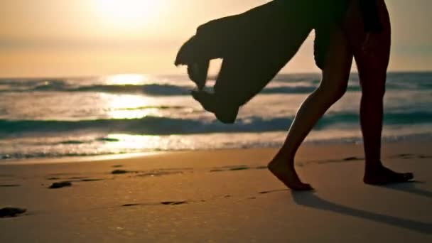 太阳升起时 瘦弱的女人赤着腿在潮湿的海滨行走 不知名的非洲裔美国女孩穿着飘扬的长袍独自走着美丽的海滩 年轻的赤脚女士喜欢早上的夏季海景 — 图库视频影像