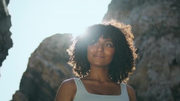 Glimlachende Afro Amerikaanse Vrouw Staande Rotsachtige Strand Verlicht Fel Zonlicht — Stockvideo