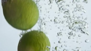 Güzel limonlar arka planda su sıçratır. Tropikal meyveler şeffaf kabarcık sıvısı damlatırlar. Turunçgil ile lezzetli bir fitness kokteyli hazırlıyorum. Yeşil yaz partisi rahatlama konsepti.