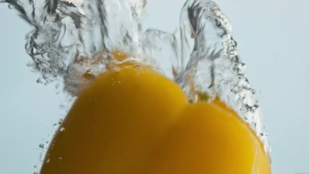 ベルペッパーは水を閉じます 泡状の液体の光の背景に美しい新鮮な野菜スプラッシュ 黄色の夏のパプリカが跳躍浮かんでいます 健康的なフィットネス栄養 生の食品の商業的ショット — ストック動画