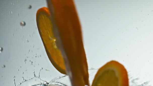 Pomarańczowe Kawałki Spadające Bliska Smaczne Plasterki Słodkich Owoców Rozpryskują Przezroczysty — Wideo stockowe