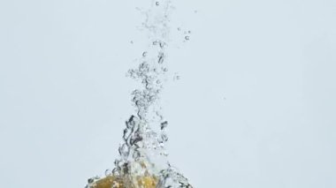 Baloncuklarda düşen limon suyu yakın plan. Yaz aylarında taze narenciye yüzeyi. Lezzetli ekşi vitamin akışı kristal berraklığında. Organik sağlıklı beslenme. Limonata içeceği konseptini tazeliyorum.