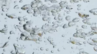 Hava kabarcıkları yükselen su yüzeyini kapatıyor. Hafif arkaplanda kaynayan mineral sıvısı. Kaynar su ısıtıcısında çeşitli hava kabarcıkları akıyor. Köpüklü içecek ferahlatıcı. Sıhhat nemlendirici kavram.