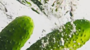 Taze sebzeler köpüklü suyla kapanıyor. Şeffaf sıvının içine serpiştirilmiş taze salatalık kiraz domatesleri. Sağlıklı salata için yaz organik malzemeleri. Fitness pişirme zevki.