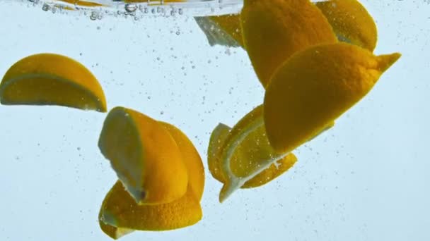 Cuñas Naranjas Frescas Sumergidas Bajo Agua Transparente Cámara Súper Lenta — Vídeo de stock