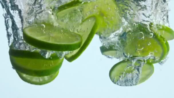 Het Laten Vallen Van Sappige Limoenschijfjes Onder Helder Water Super — Stockvideo