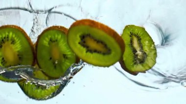 Lezzetli kivilerin tatlı sularını süper yavaş çekimde yakın çekimde kesiyor. Sulu vitamin meyvesi beyaz zemine şeffaf sıvı damlatır. Meyve suyu için tropik organik bileşenler sağlıklı içecekler..