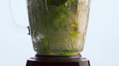 Çok yavaş çekimde elektrikli mikserle lezzetli sebze kokteyli hazırlıyorum. Dilimlenmiş taze meyve sebzelerini cam karıştırma kabında karıştırıyorum. Sağlıklı beslenme için organik gıda.