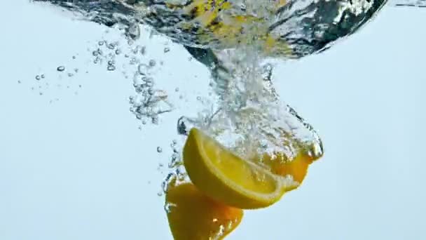 Šťavnaté Oranžové Kousky Ponořil Čiré Vody Dělat Bubliny Bílém Pozadí — Stock video