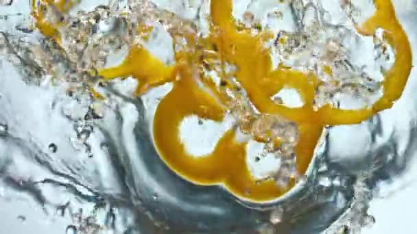 Шматочки Жовтого Перцю Розбризкують Прозору Воду Дуже Повільному Русі Крупним — стокове відео