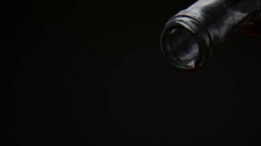 Kırmızı şarap damlaları cam şişeden dökülüyor. Siyah arka planda boynu var. Son damlaya damlaya damlaya damlaya, boş konteynırdan damlaya damlaya damlaya, süper yavaş çekimde. Bağcılık şarap konsepti. 
