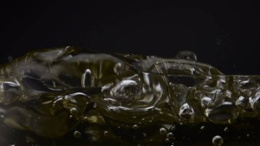 Soğuk buz küpü, siyah arka planda temiz şarap kadehinin içine beyaz şarap sıçratıyor. Bardakta sallanan serin, ferahlatıcı alkol içeceği. Donmuş blok şeffaf kadehi süper yavaş çekimde düşürüyor..