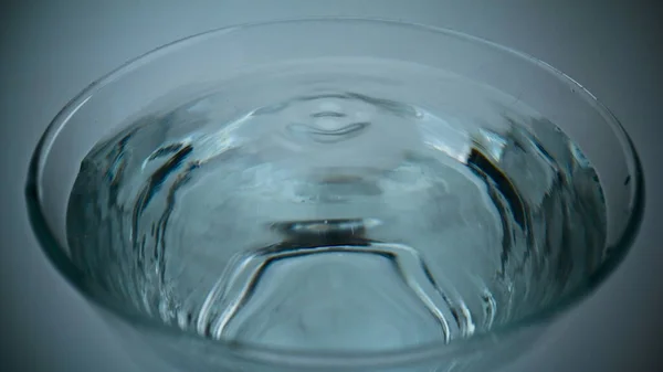 超スローモーションマクロに落ちるきれいな水のドロップ 透明なさわやかな液体ガラスを振って閉じます ろ過された飲料の塊穏やかな表面 ドリンクドリブルサークルの形状トップビューを作る 三番目の概念 — ストック写真