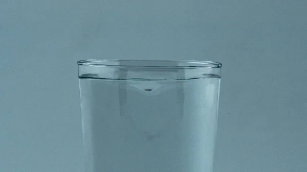 純飲料透明なシリンダーを閉じる回転 きれいなガラスの確立にミネラルウォーター渦 液体表面マクロの波 船内で冷たい飲み物超遅い動き ろ過されたアクア回転 — ストック写真