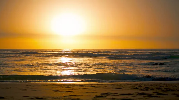 피카소의 광경은 대서양의 표면에 주황색 반사되어 해변을 보여준다 모래사장에서는 파도가 — 스톡 사진