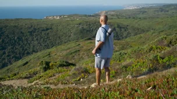 Pria Atletik Berjalan Lapangan Jalan Dengan Yoga Tikar Pemandangan Laut — Stok Video