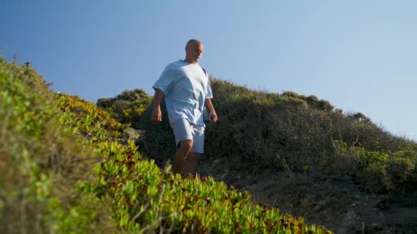 Man Walking Mountain Path Holding Yoga Mat Sunlight Athletic Guy — Stock Video
